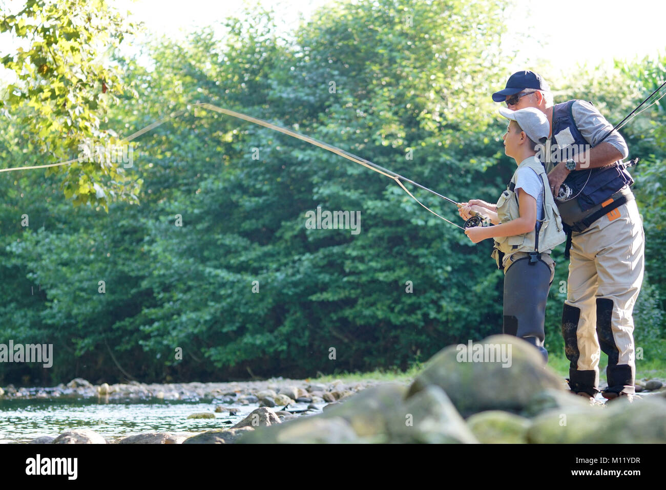 Father teaching son how to flyfish in river Stock Photo Alamy