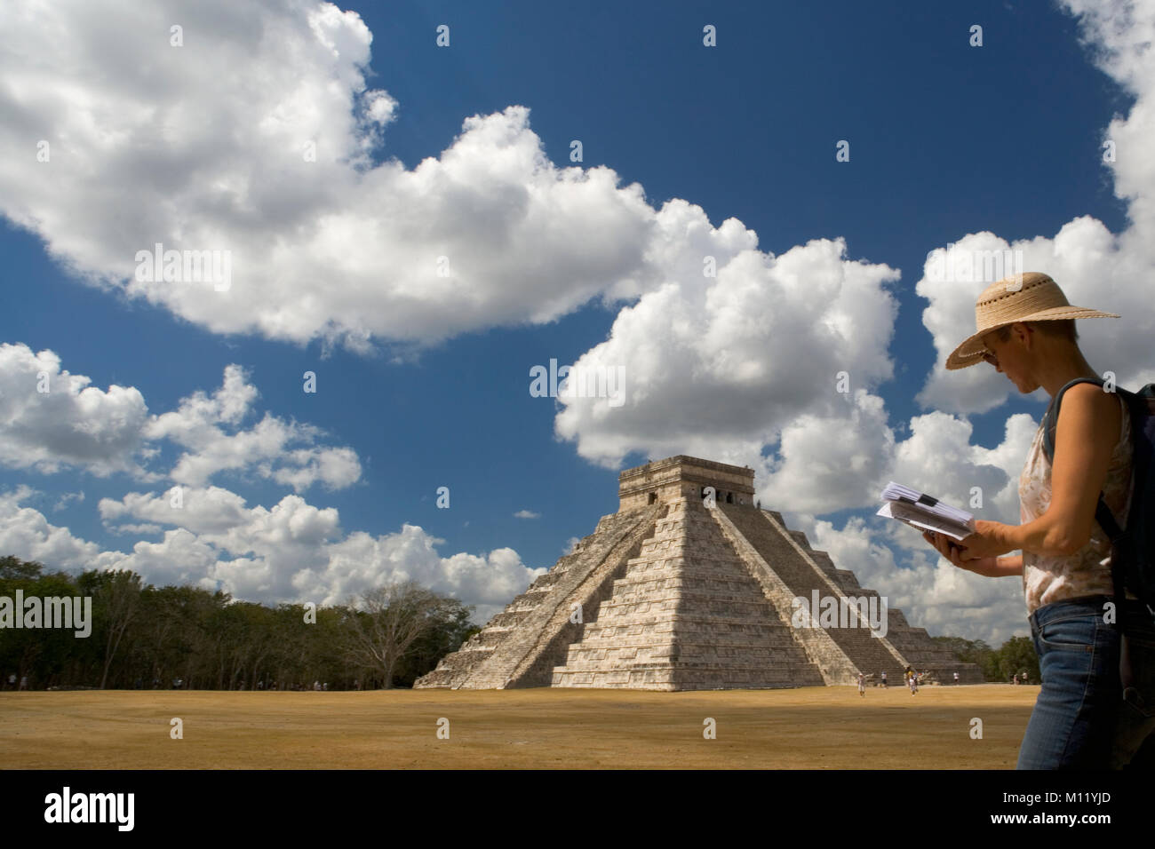 Mexico. Yucatan. Chichen Itza. Maya ruins. Maya-Toltec ruins, El Castillo. Female tourist at pyramid. Stock Photo