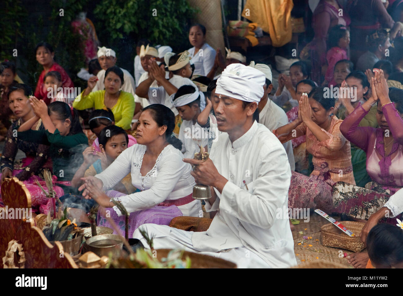Indonesia, Island Bali, Tejakula village, Pura Maksan Temple. Hindu priest and people worshipping. Stock Photo