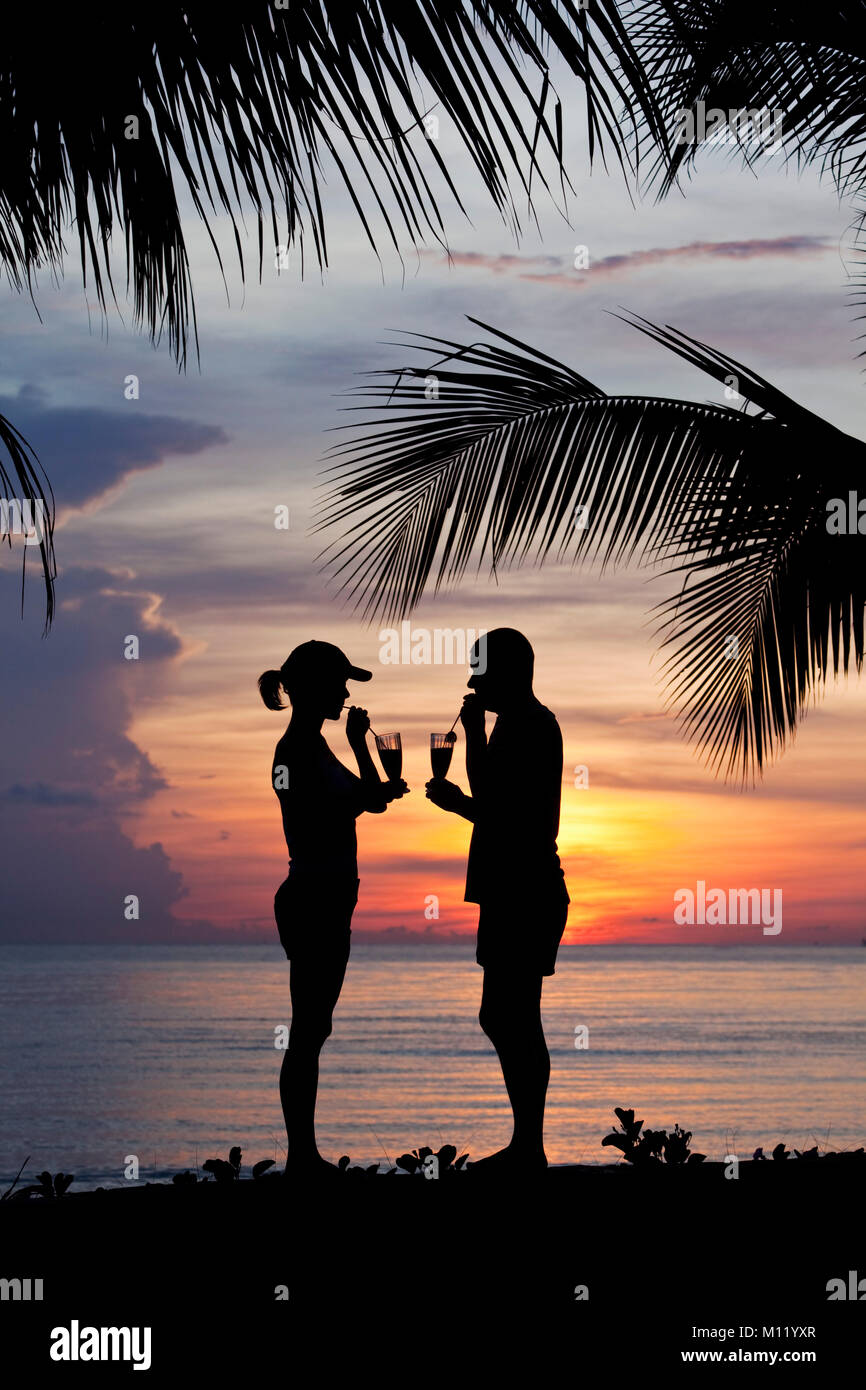 Indonesia, Island Bali, near Tejakula village, Gaia Oasis Resort. Couple having a drink at sunset. Stock Photo
