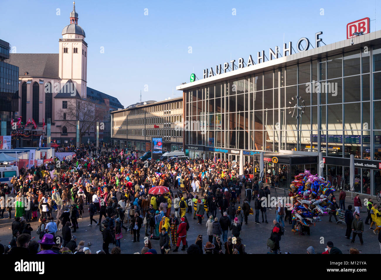 Germany, Cologne, carnival, Shrove Monday procession, crowd in front of the main station, church St. Mariae Himmelfahrt.  Deutschland, Koeln, Karneval Stock Photo