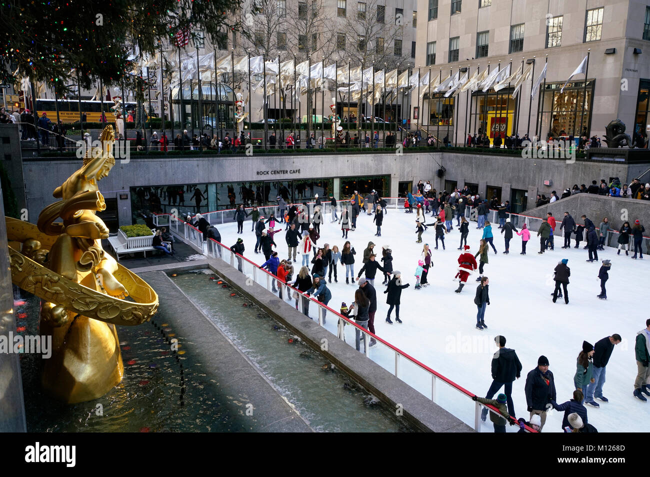 The ice skating rink in Rockefeller Center with the golden Prometheus sculpture in foreground.winter holiday season.Manhattan.New York City.USA Stock Photo