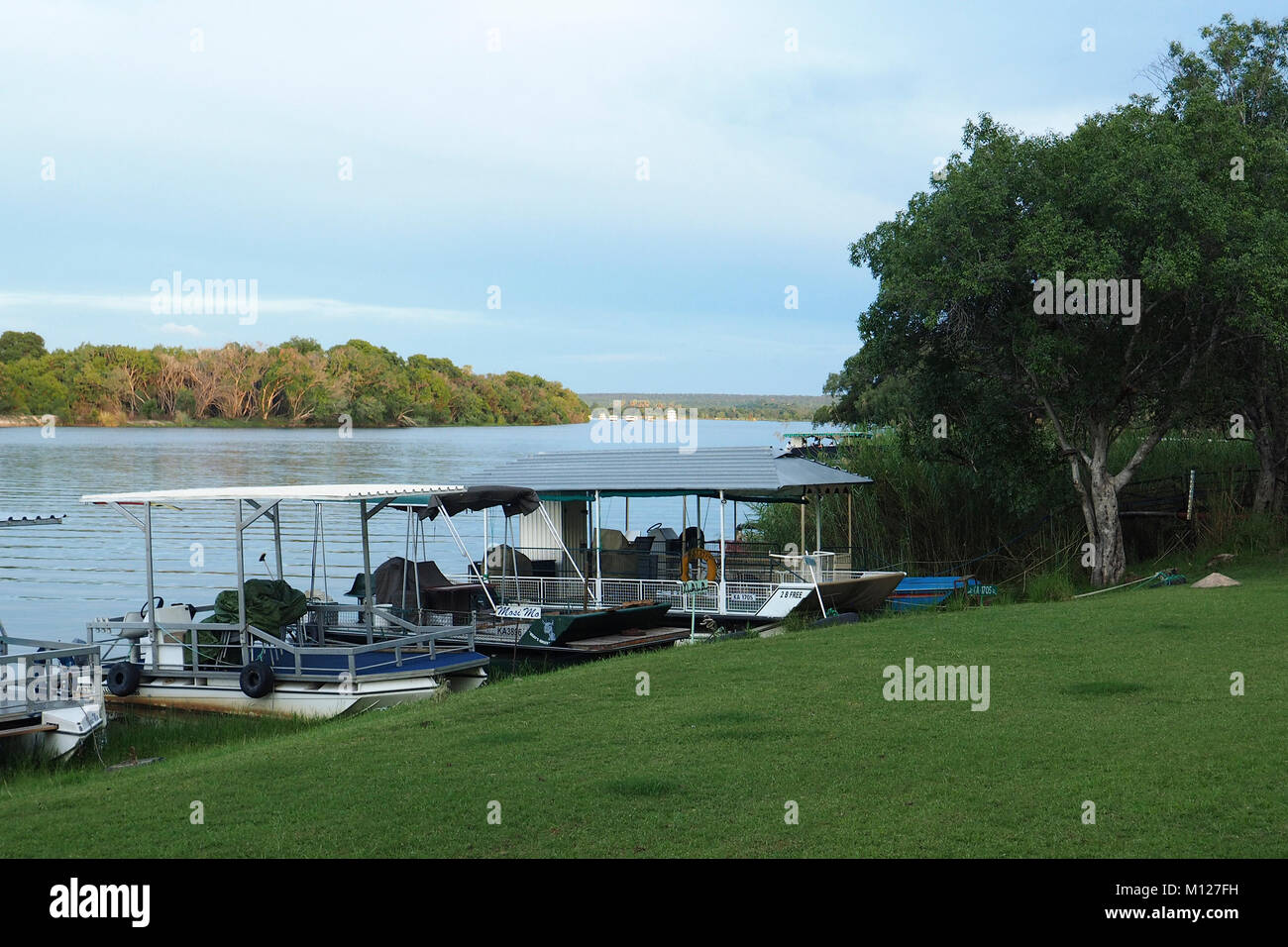 VICTORIA FALLS, ZIMBABWE, AFRICA - December 21, 2017:   Tour  sightseeing boats moored along the Zambezi River Stock Photo