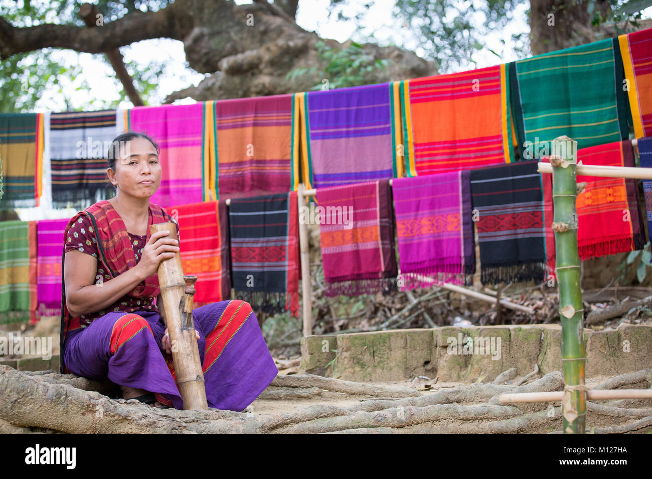 Bangladeshi woman smoking a big bamboo pipe Stock Photo