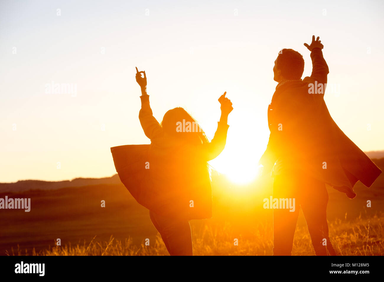 Happy couple is dancing against sunset Stock Photo