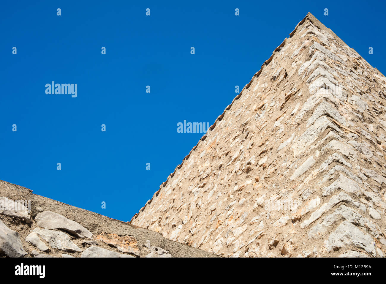 Detail of mediterranean country house made of stone on a sunny day in blue background in Catalonia. Stock Photo
