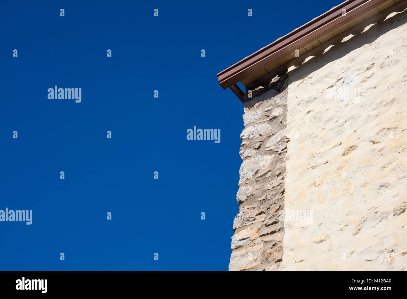 Detail of mediterranean country house made of stone on a sunny day in blue background in Catalonia. Stock Photo