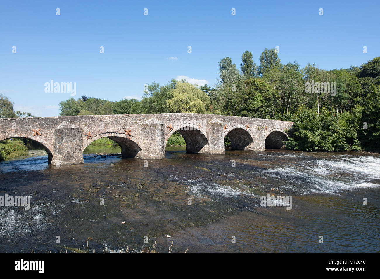 The River Exe flows under the medieval stone bridge at Bickley in Devon England Stock Photo