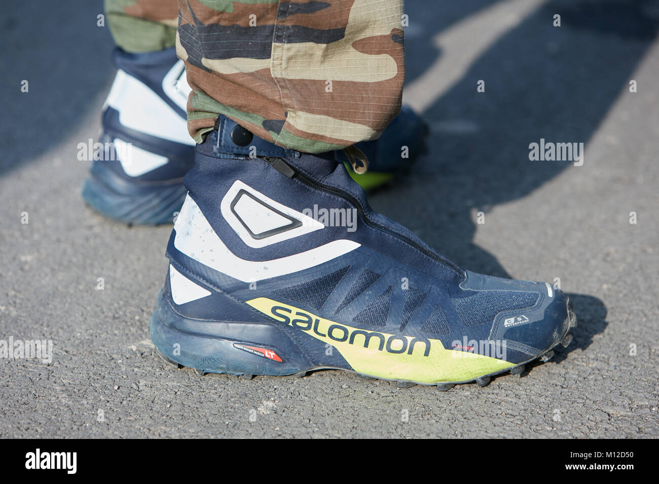 MILAN - JANUARY 14: Man with Salomon blue and yellow shoes and green  camouflage trousers before Dsquared 2 fashion show, Milan Fashion Week  street sty Stock Photo - Alamy