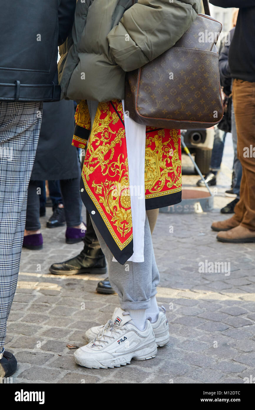 A man in louis vuitton outfit he has nice sneakers on and he wears a bag