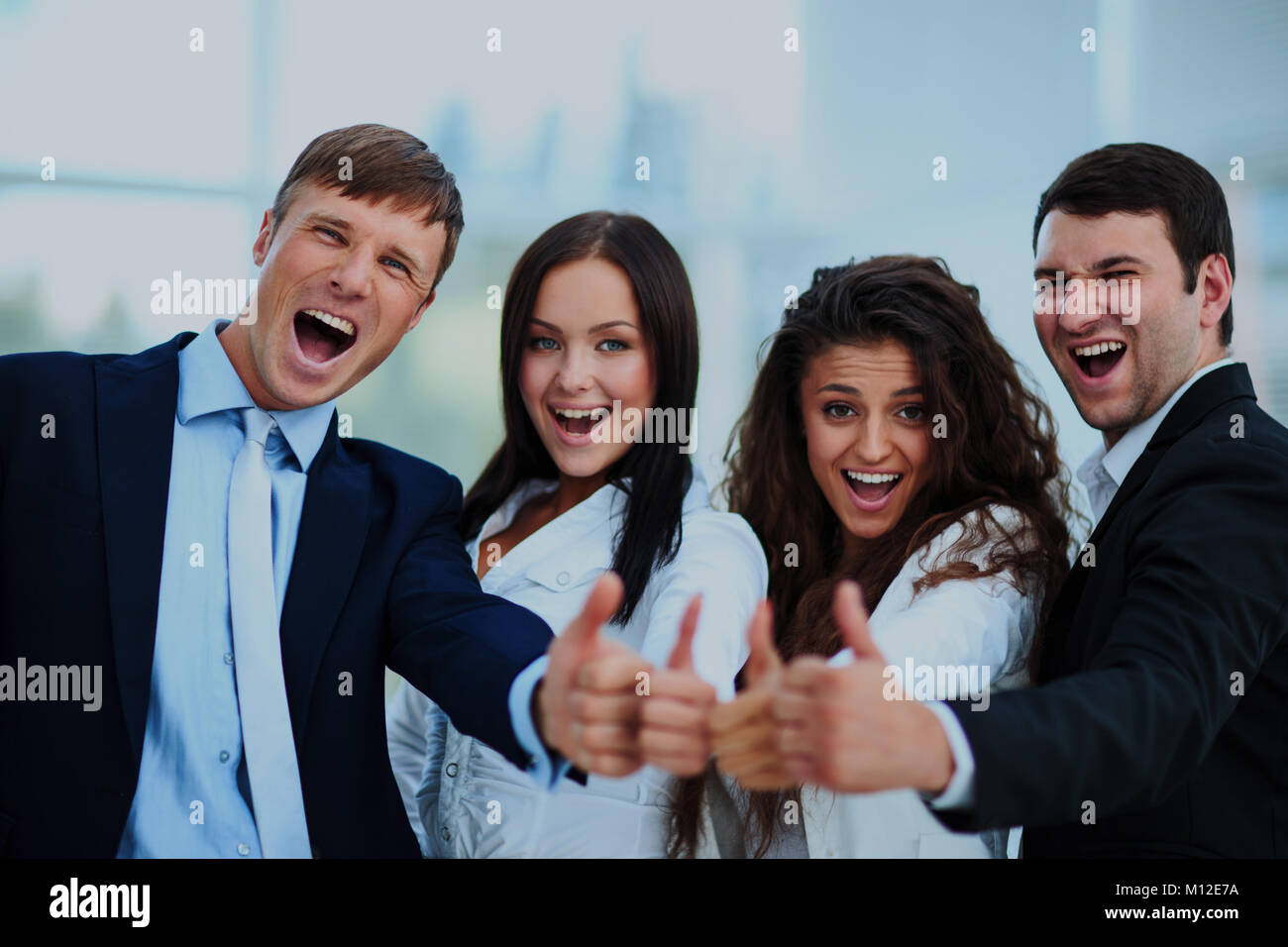Happy business team with thumbs up in the office Stock Photo - Alamy