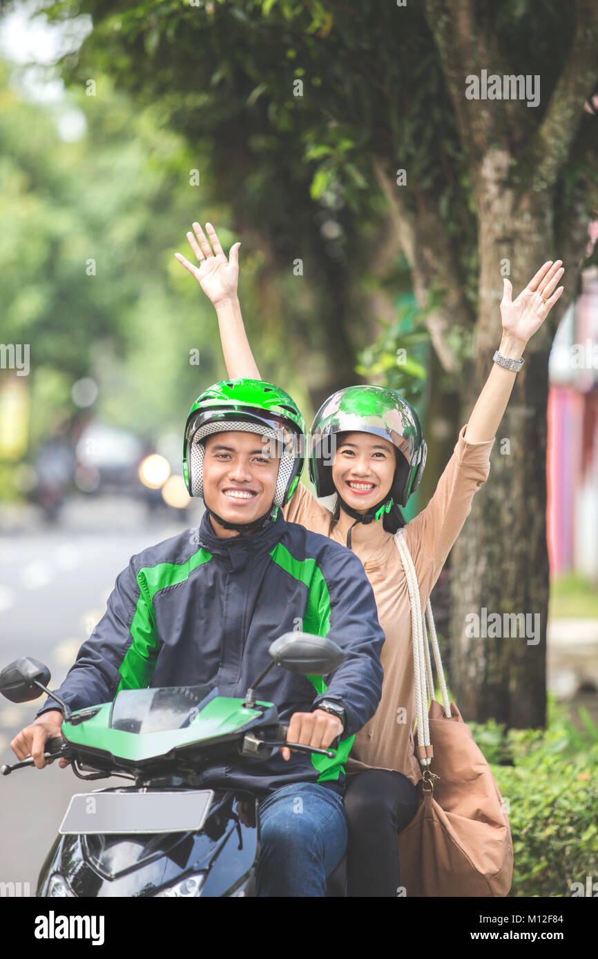 Happy excited commercial motorcycle taxi driver taking cheerful ...