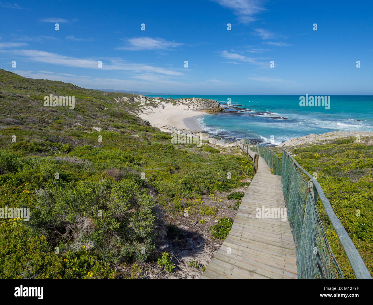 De Hoop Nature Reserve - Wooden walkway leading down to beautiful little bay with coastal vegetation, South Africa Stock Photo