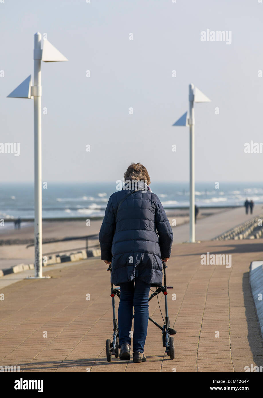 The East Frisian North Sea island of Norderney, winter, elderly lady with rollator, on the promenade on the northern beach, Stock Photo