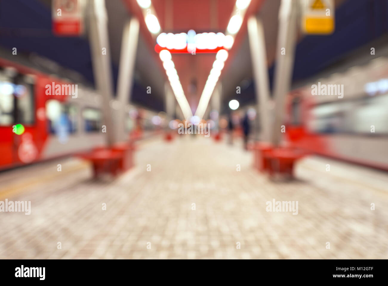 Blurred image of the highspeed trains stand by the station platform at evening time. Stock Photo