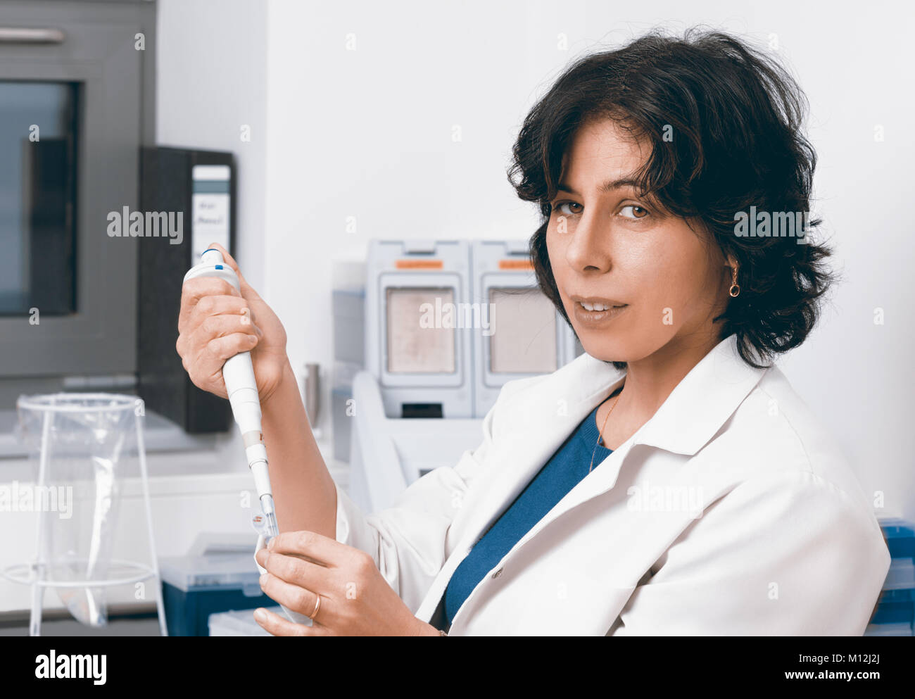 Senior scientist works with automatic pipette, toned image Stock Photo