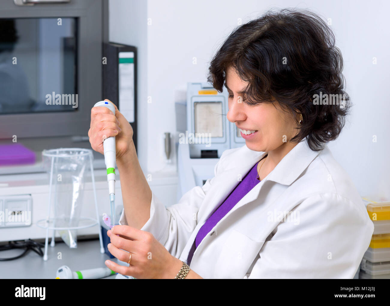 Senior scientist works with automatic pipette in biological laboratory Stock Photo
