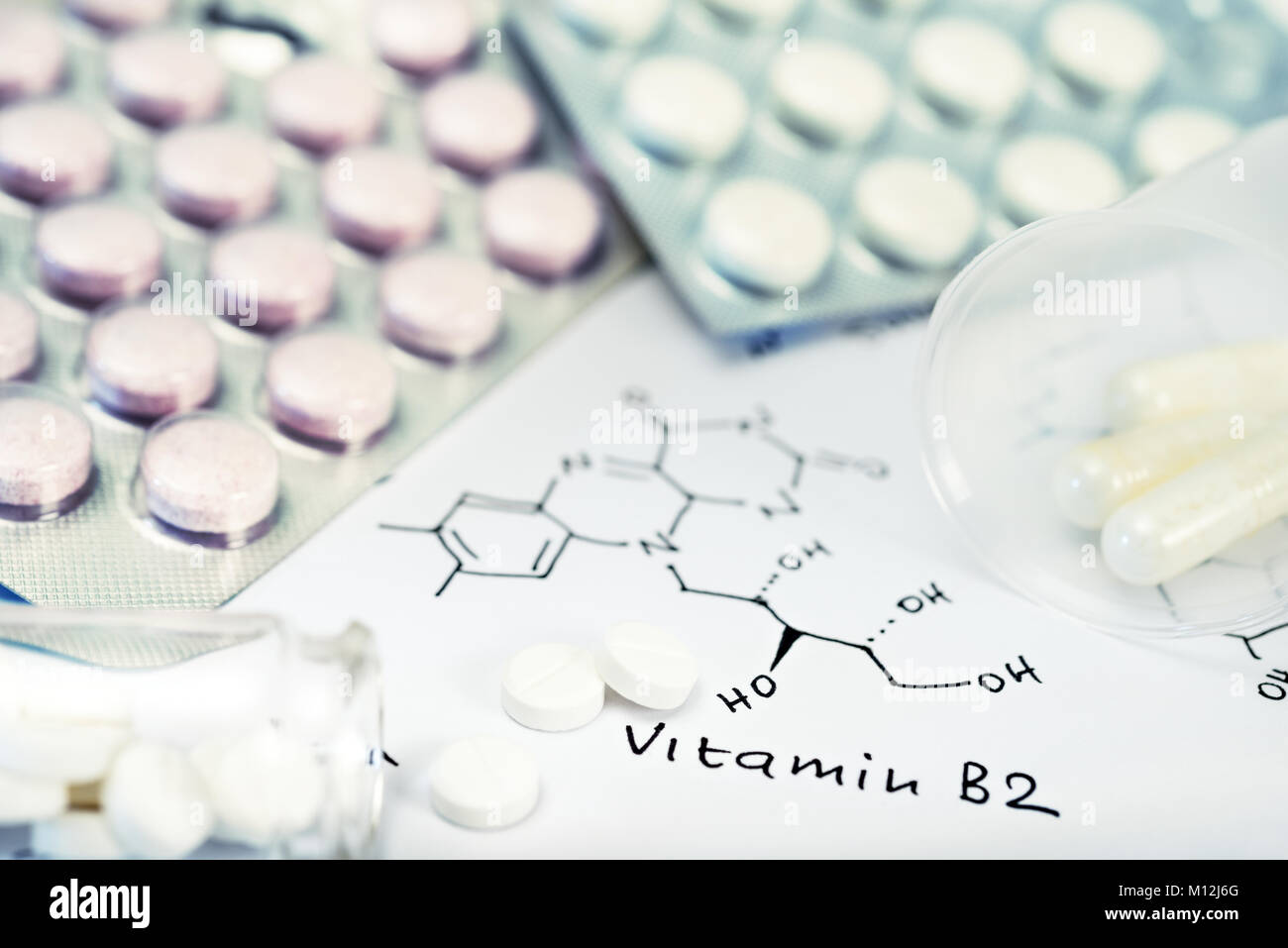 Background with pills and chemical formula of vitamin B2, shallow DOF ...