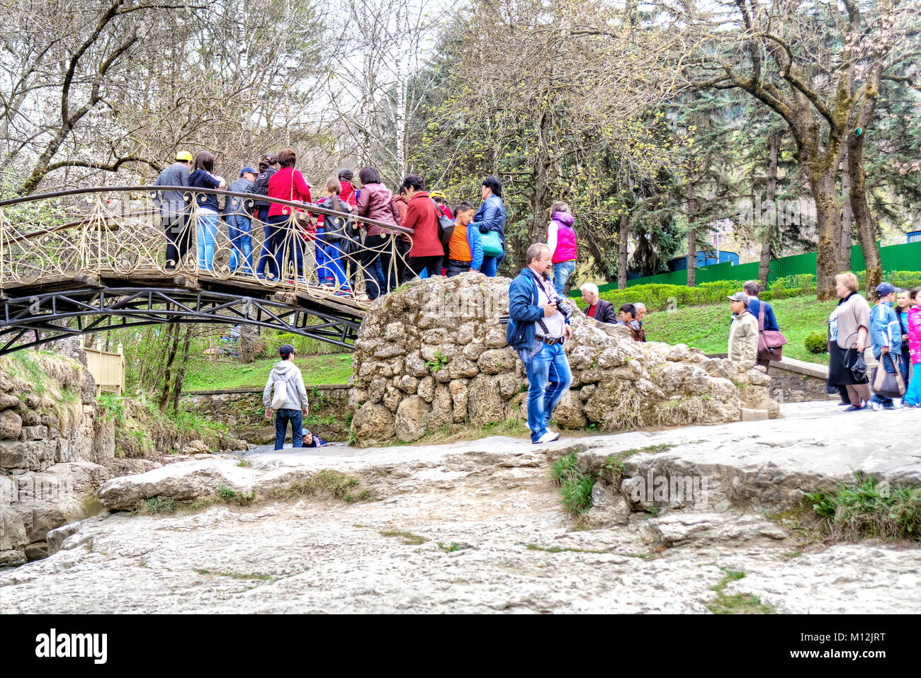 KISLOVODSK, RUSSIA - April 30.2015 : Tourists from a bridge examine the mountain river Olhovka in a municipal park Stock Photo