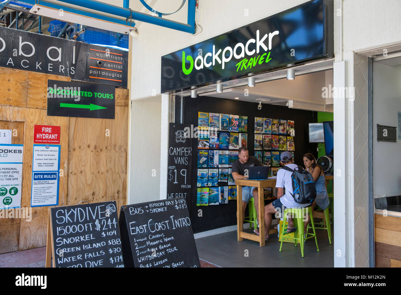 Two backpackers receiving travel advice from the agent at Backpacker travel in Cairns city