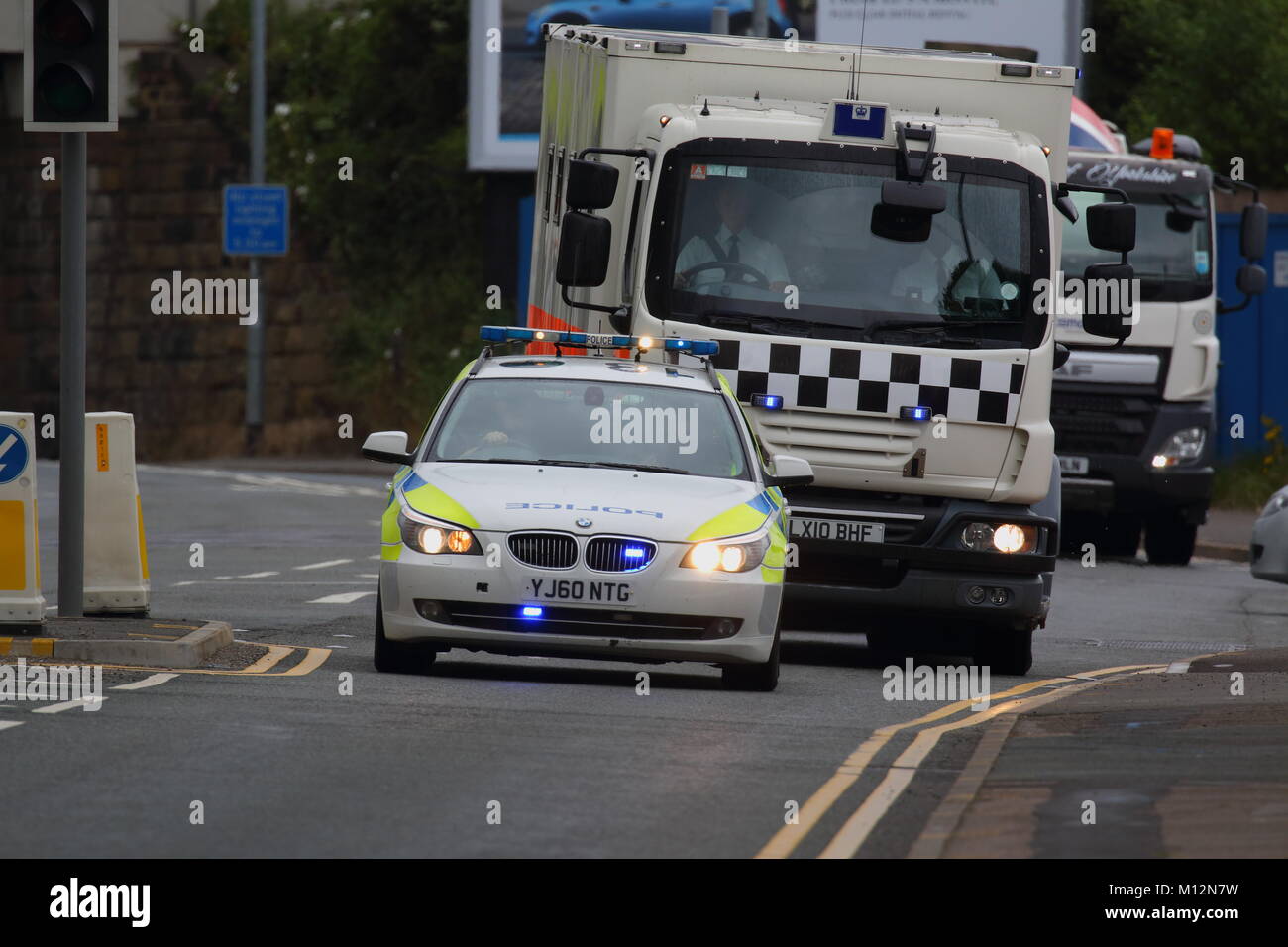 A convoy of police vehicles escorting a prisoner from Elland Road Police Station Stock Photo