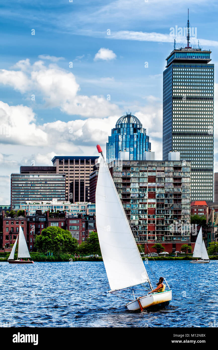 Sailing on the Charles River between Cambridge and Boston on a windy day, with Beacon Hill seen in the background. Sailboat in the foreground. Stock Photo