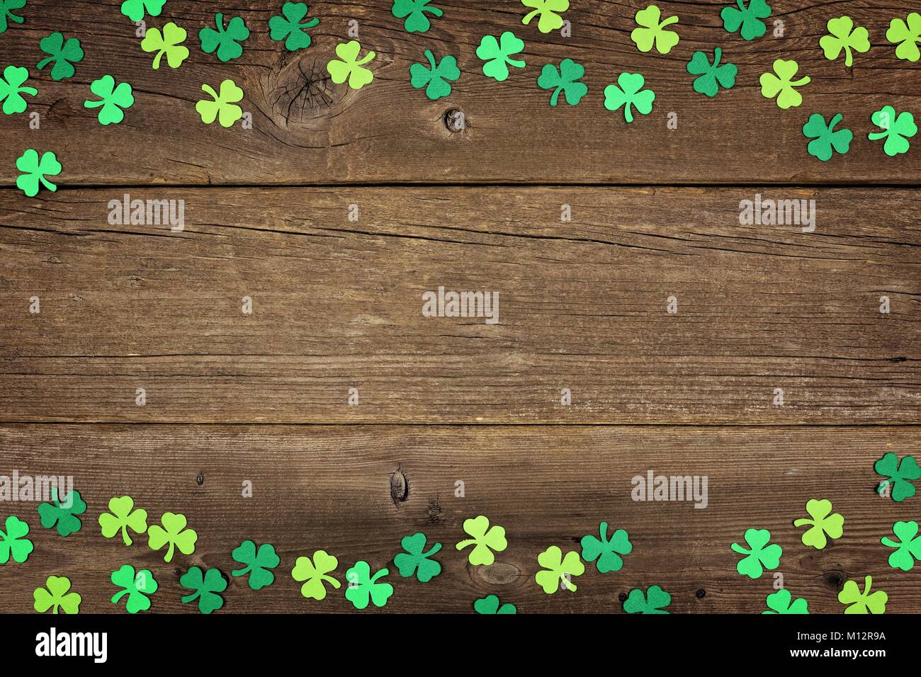 St Patricks Day double border of paper shamrocks over an old rustic wood background Stock Photo