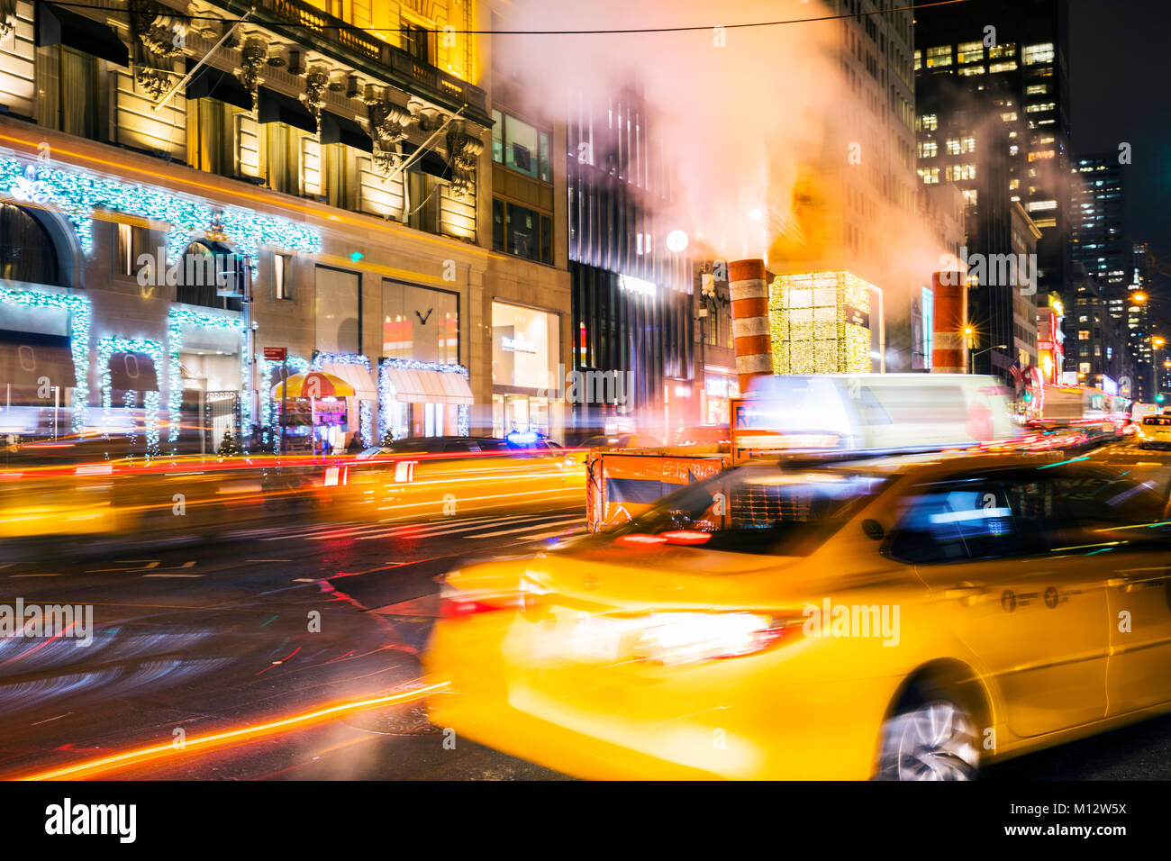 Yellow taxi at fifth avenue in New York City at night Stock Photo