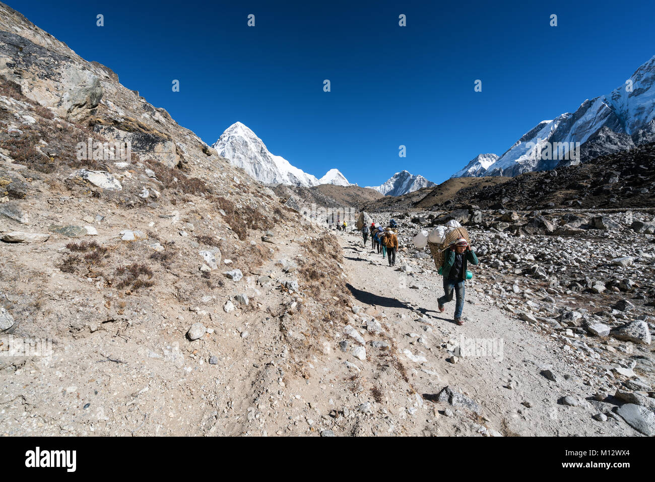 Sherpa porters and trekkers just before arriving to Gorak Shep, Nepal ...