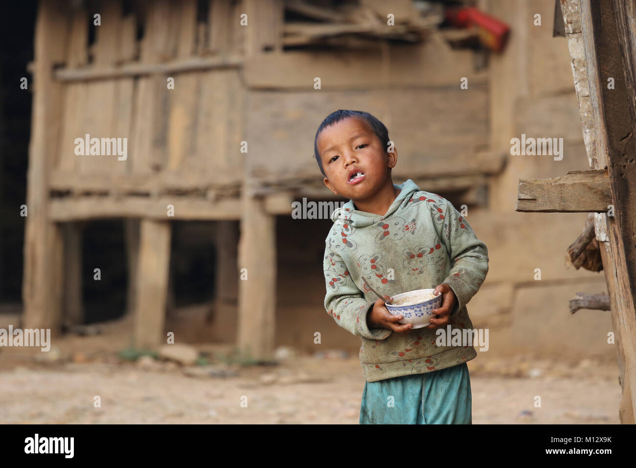 Young boy at breakfast in a small village in Phongsali Province, Northern Laos, Indochina Stock Photo