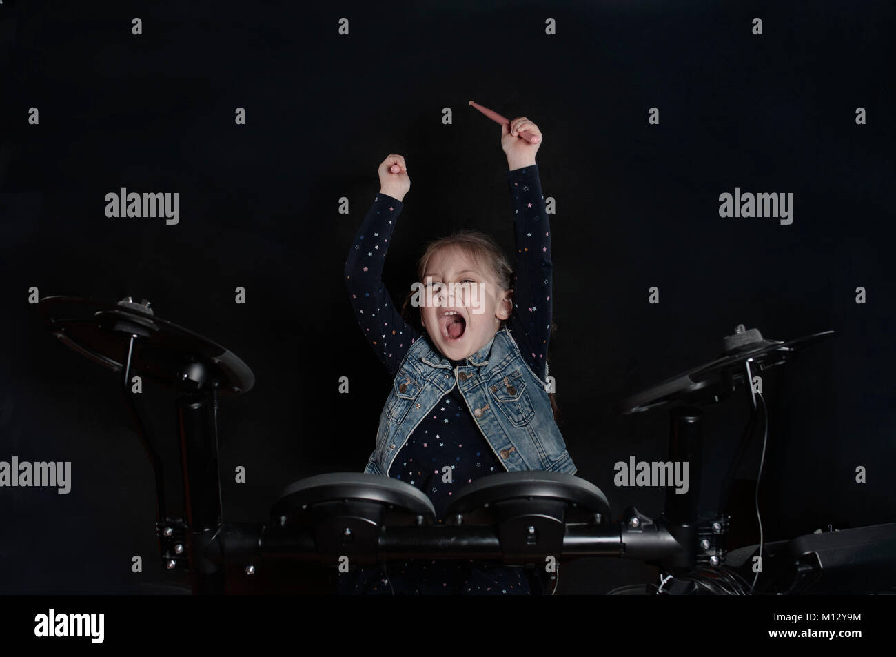 Little caucasian girl drummer play the elettronic drum kit Stock Photo