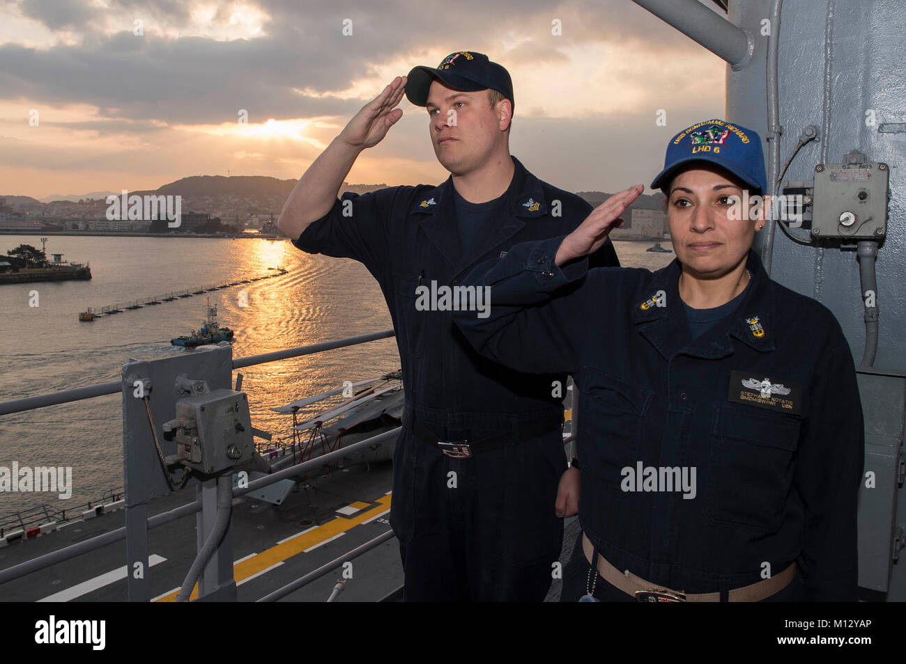SASEBO, Japan (Jan. 23, 2018) Master Chief Quartermaster Stephanie Kortatis, right, from Sayreville, N.J., and Quartermaster 1st Class Matthew Lenerville, from Richardton, N.D., render honors during morning colors aboard the amphibious assault ship USS Bonhomme Richard (LHD 6) prior to the ship’s departure from Sasebo, Japan. Bonhomme Richard is underway conducting a Readiness for Sea assessment ahead of a regularly scheduled patrol in the Indo-Asia-Pacific region. (U.S. Navy Stock Photo