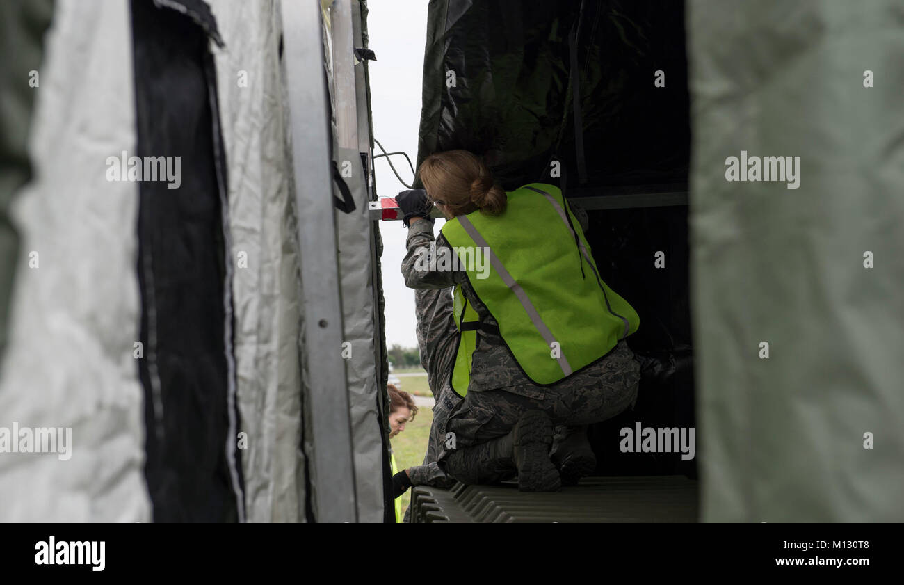 A member of the 18th Medical Group assemble a tent near the flightline ...
