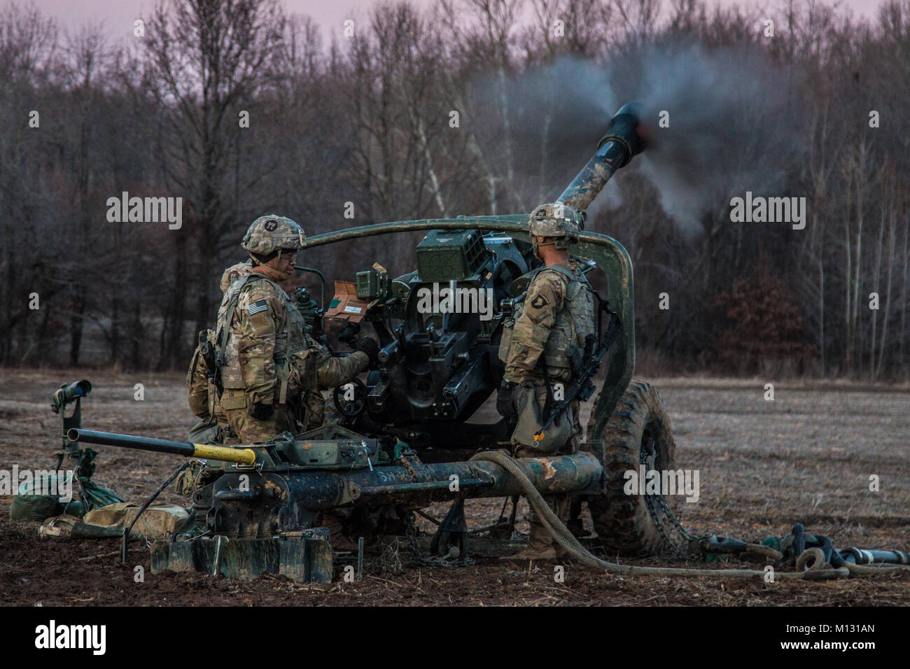 Artillerymen from B. Battery, 3-320th Field Artillery, 101st Airborne Division Division Artillery, 101st Airborne Division (Air Assault) fire the Howitzer M119A3 during platoon validation firing January 24 on Fort Campbell. The Howitzers were sling loaded into place from 3 UH-60 Black Hawks. Stock Photo