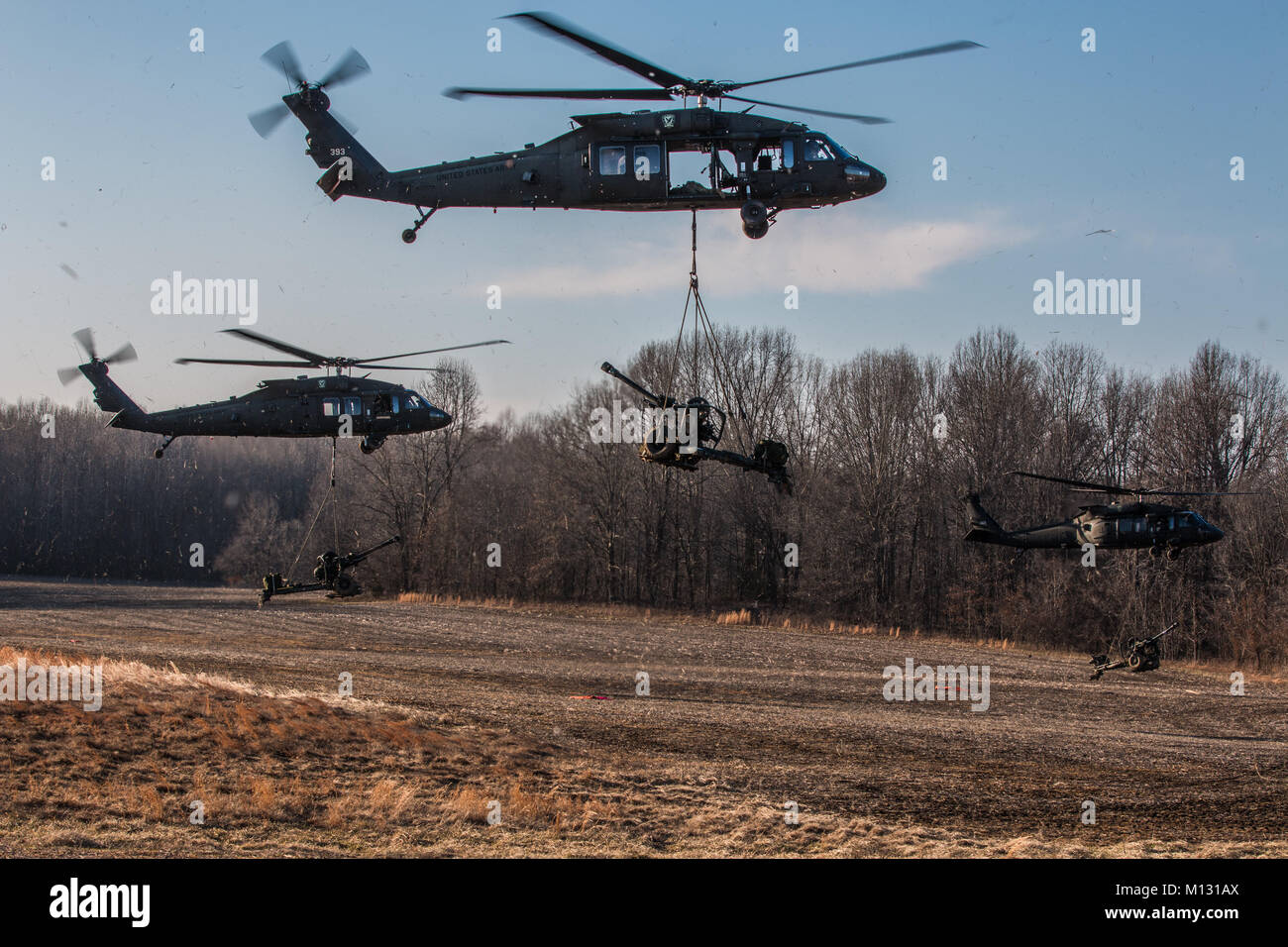 UH-60 Black Hawks sling load Howitzer M119A3s to the firing point January 24 on Fort Campbell. Sling loading the Howitzers allows the artillerymen to more rapidly in place in remote locations to effectively fire upon the enemy. Stock Photo