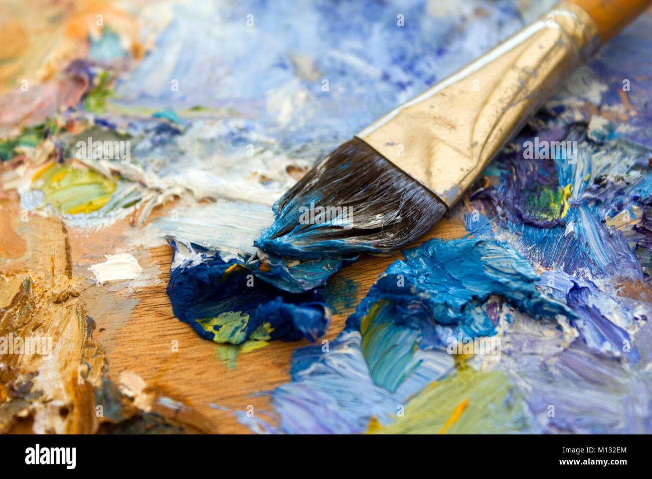 Vibrant multi-coloured artists oil paint palette. Shallow depth of