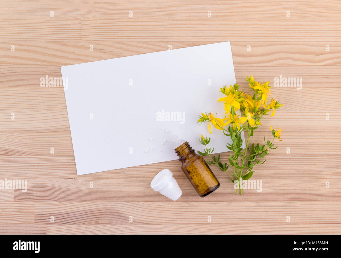 Homeopathic remedy with flowering St. John's wort with white copy space on a wooden background Stock Photo