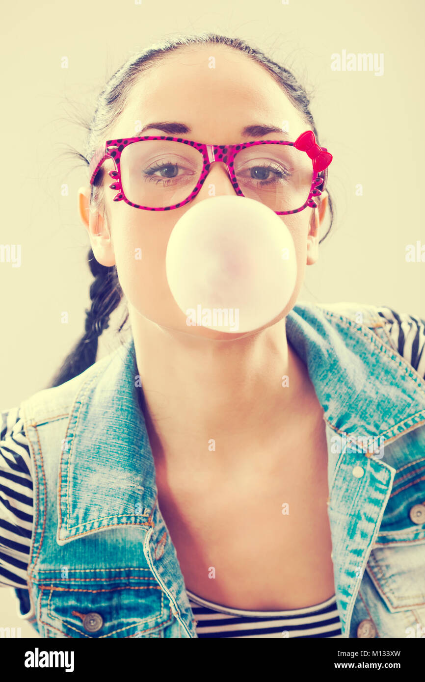 Young woman blowing bubblegum, intentionally toned. Stock Photo