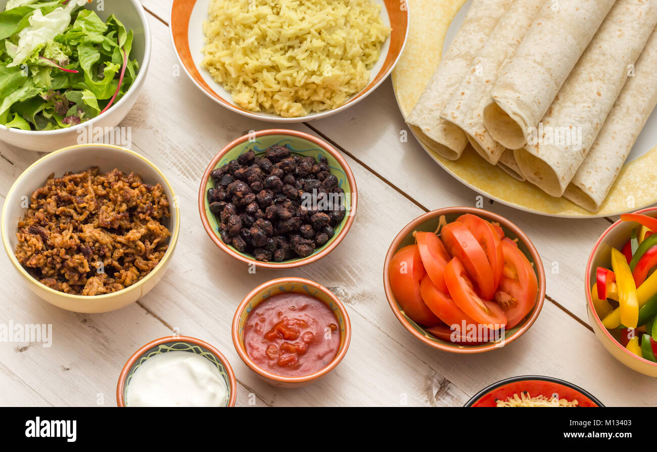 Ingredients to make mexican burritos with tortillas, rice, beans