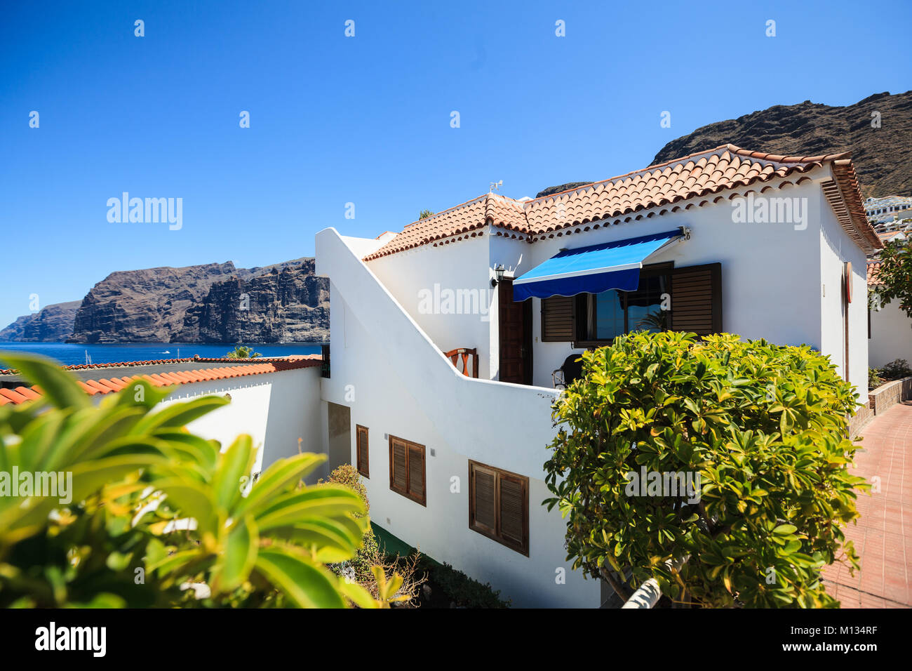 residential apartments with sea port of Los Gigantes in the background, Tenerife, Spain Stock Photo