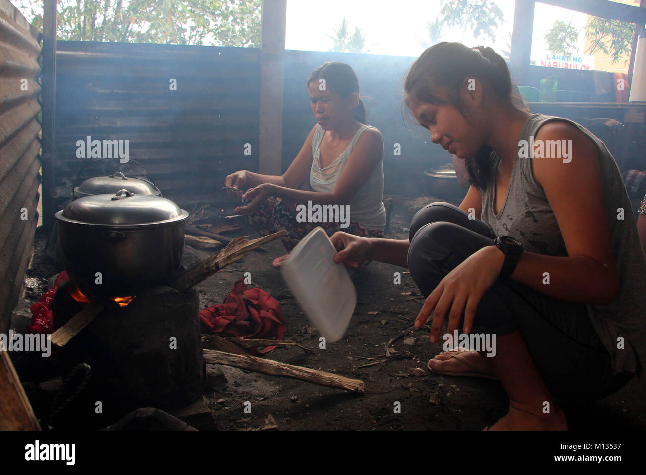 Rea Mae Madrona, 13 yrs old, while cooking foods using woods from Brgy. Baligong inside Ligao City National Technical Vocational High School LigaoCity, Albay, Bicol on January 26, 2018. The Philippine Institute of Volcanology and Seismology (PHILVOLCS) declared alert number 8 and wider the danger zone to 8 kilometers area after explosions the continues active activities of the volcano this past several days. According to the reports it's a total of 74,000 individuals are affected and 100 million of damages in the agricultural land according to Department of Agriculture (DAR). (Photo by Gregor Stock Photo