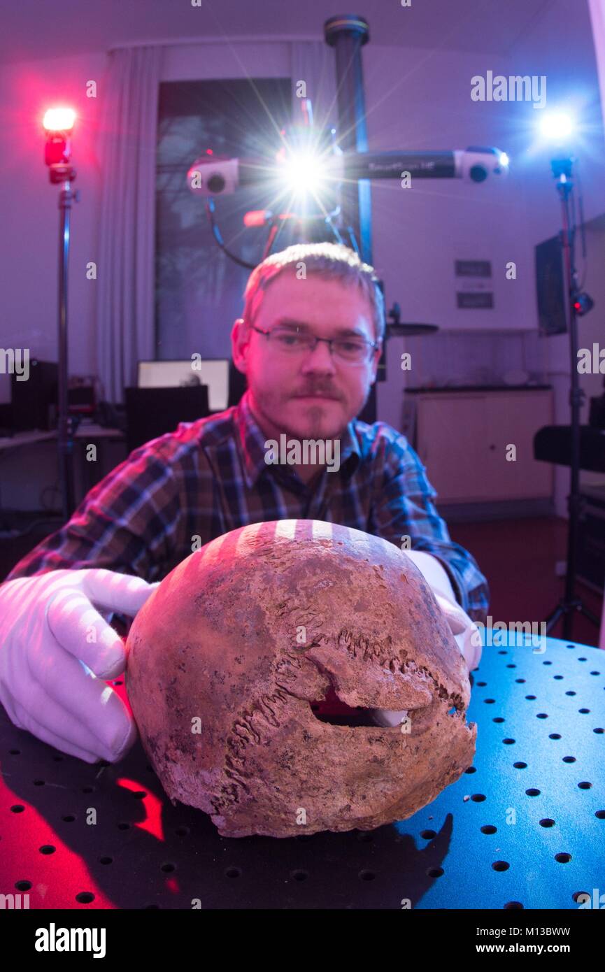 Dresden, Germany. 26th Jan, 2018. Engineer Thomas Reuter examines the 500-year-old skull of murder victim Johann Wengemeyer of Annaberg at the archeological centre of Dresden, Germany, 26 January 2018. Historians hope to solve the murder using new 3D technology. Credit: Sebastian Kahnert/dpa/Alamy Live News Stock Photo