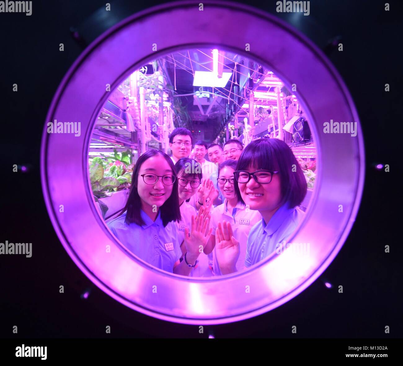 (180126) -- BEIJING, Jan. 26, 2018 (Xinhua) -- Volunteers of the first group and the second group wave in the cabin at Beihang University in Beijing, Jan. 26, 2018. Two male and two female students from Beihang University, the second group of volunteers staying in Yuegong-1, also known as Lunar Palace 1, completed the second phase of its 365-day on-ground experiment Friday, setting a world record for the longest stay in a self-contained 'cabin.' The first group of volunteers, who had previously stayed in the cabin for 60 days, re-entered the cabin to replace the second group, starting the thi Stock Photo