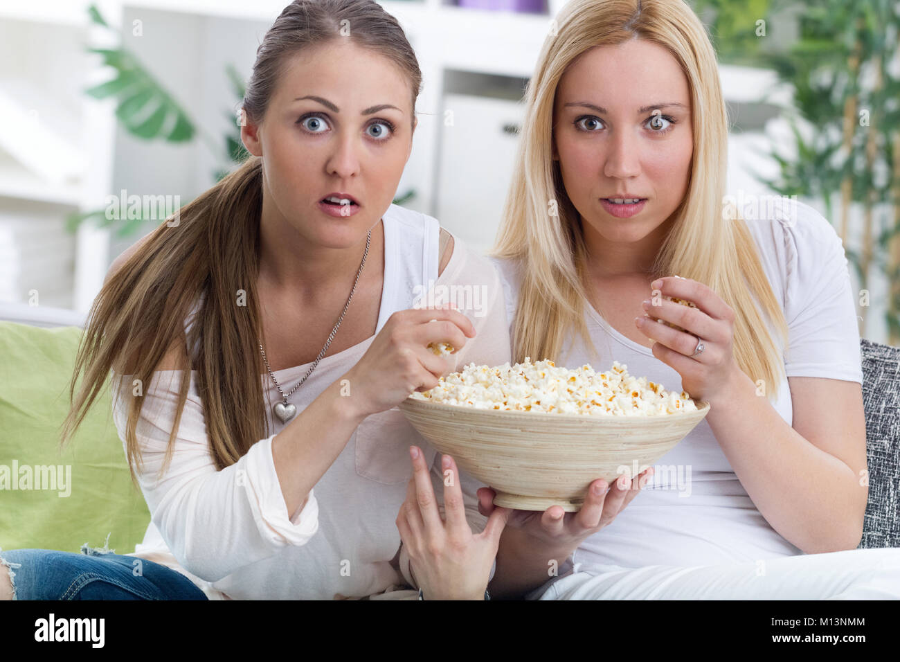 young woman watching scary movie at home Stock Photo