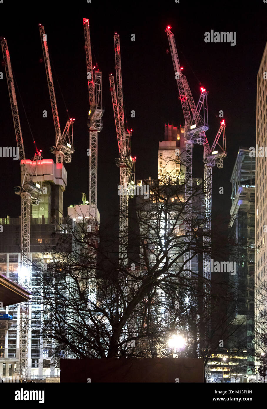 Night Photograph of Illuminated Tall Cranes on London Building Construction Site Stock Photo