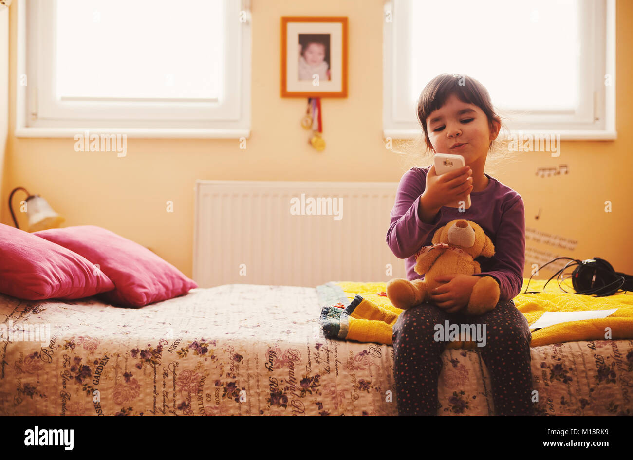 Small girl and bear toy playing and posing. Stock Photo