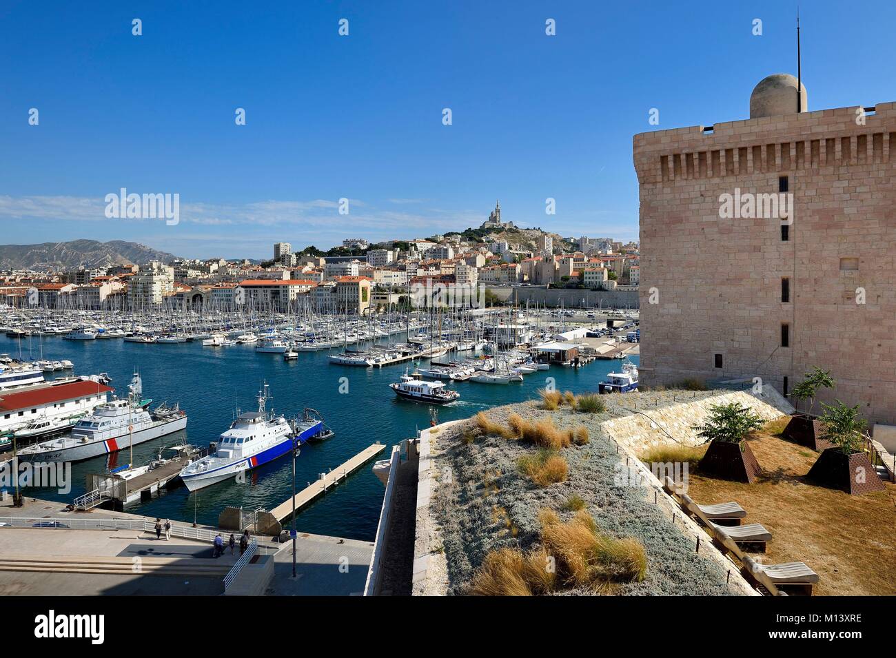 France, Bouches du Rhone, Marseille, the Fort Saint Jean at the Vieux Port entrance, the Saint Victor abbey and Notre Dame de La Garde in background Stock Photo