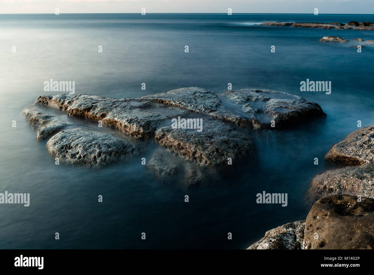 Rocks at shore long exposure Stock Photo - Alamy