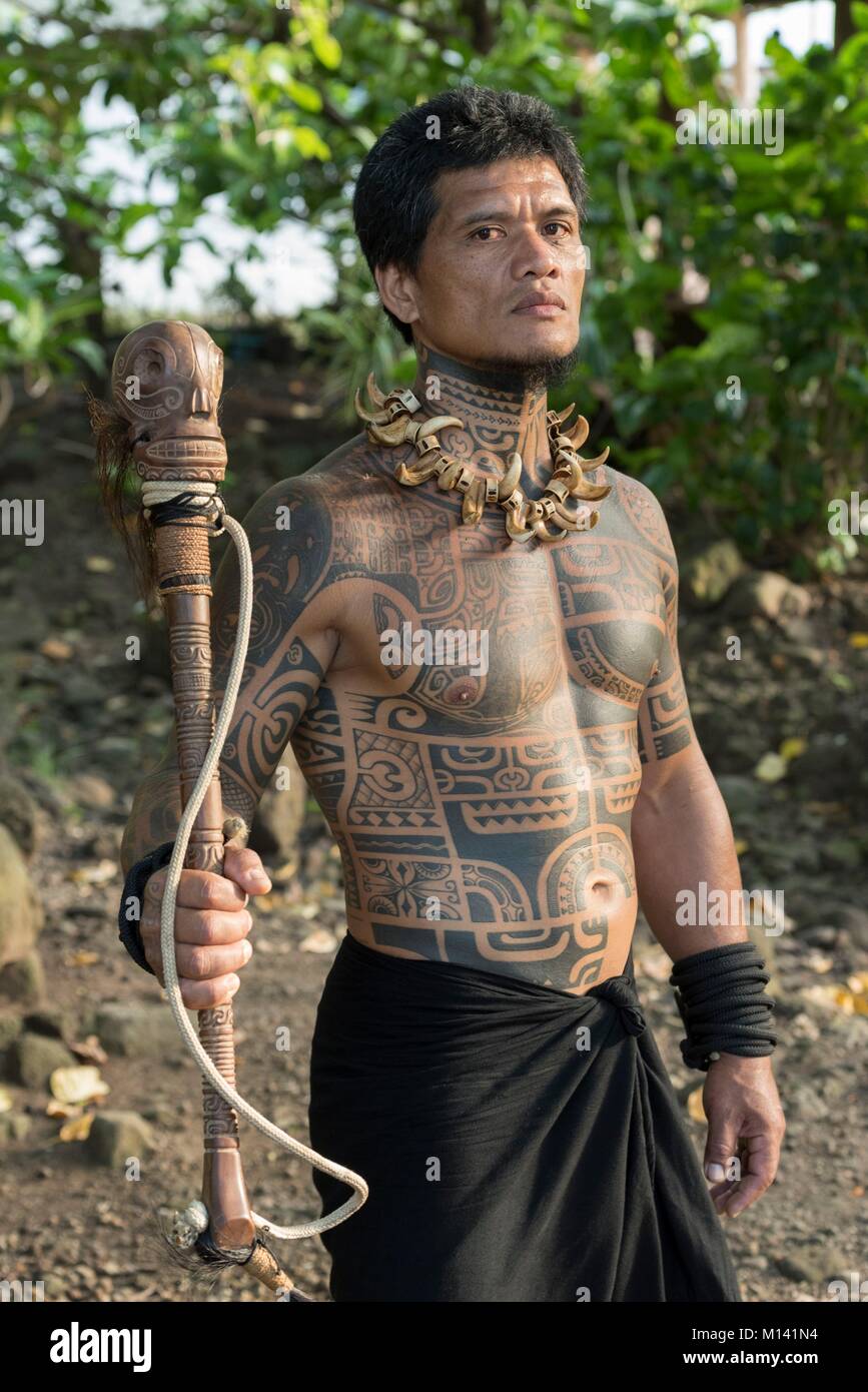 France, French Polynesia, Marquesas archipelago, Tahuata island, Hapatoni, man wearing Marquesan tattoos and a club, portrait of Tehautetua sculptor and dancer Stock Photo