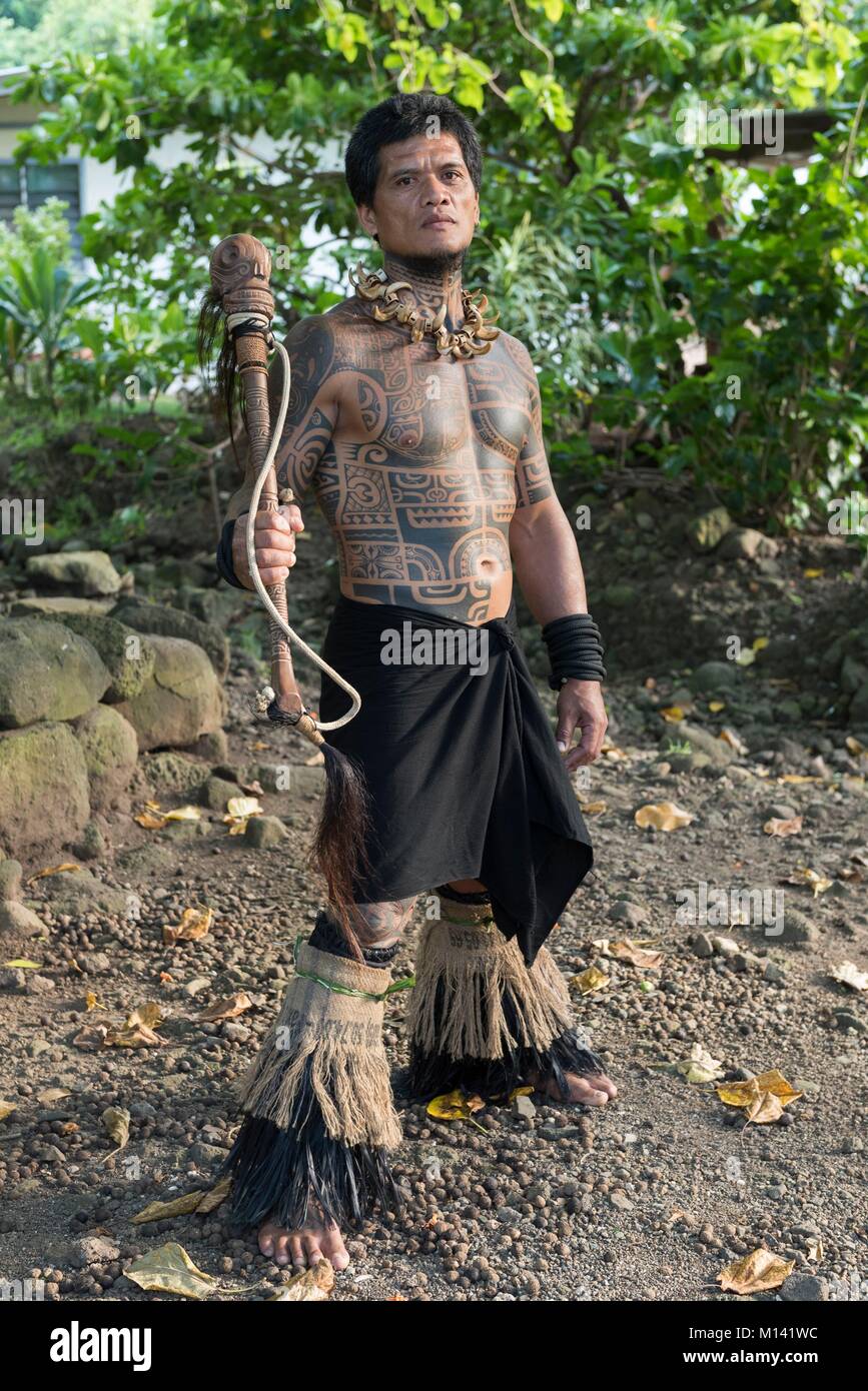 France, French Polynesia, Marquesas archipelago, Tahuata island, Hapatoni, man wearing Marquesan tattoos and a club, portrait of Tehautetua sculptor and dancer Stock Photo